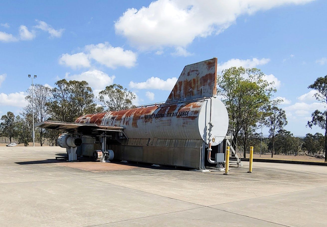 An aircraft fuselage fire trainer marked Royal Australian Air Force, standing on a concrete pad