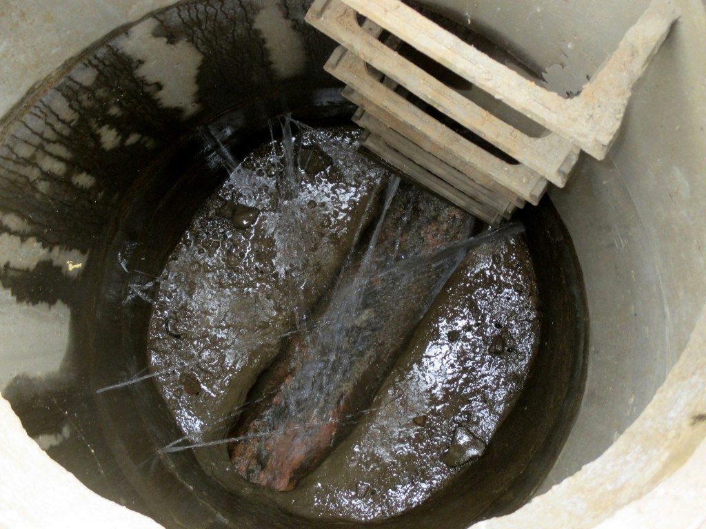 Water cascading down the step irons of a manhole during heavy rain
