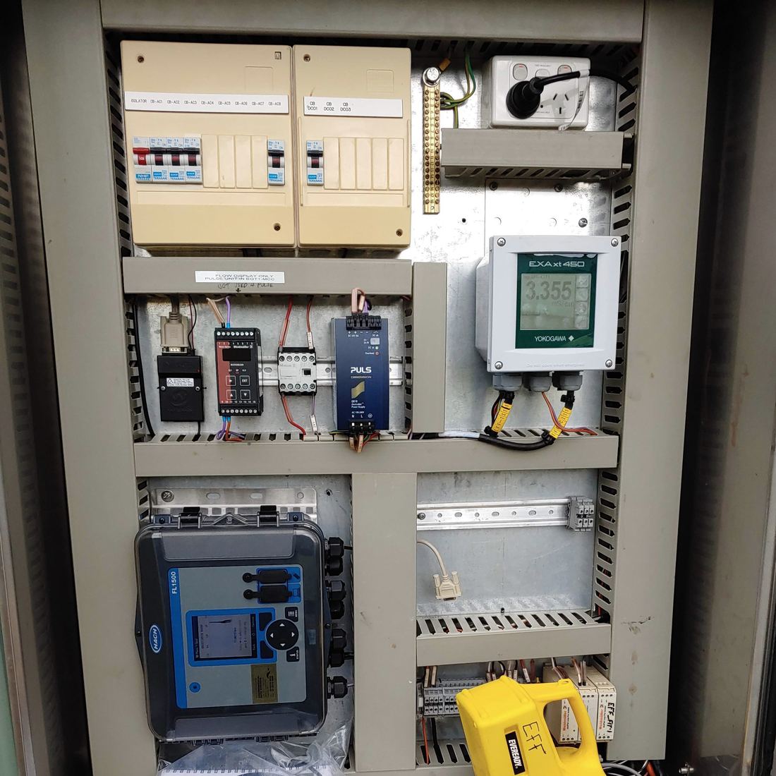 An open site cabinet with a data logger, a modem and a power supply mounted inside